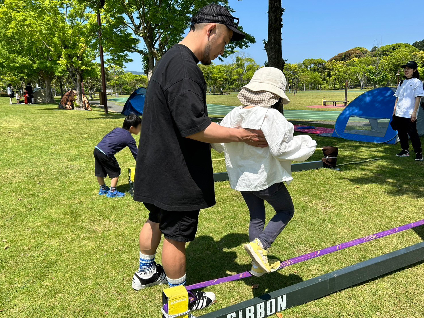 大人に支えられながらスラックラインに挑戦！