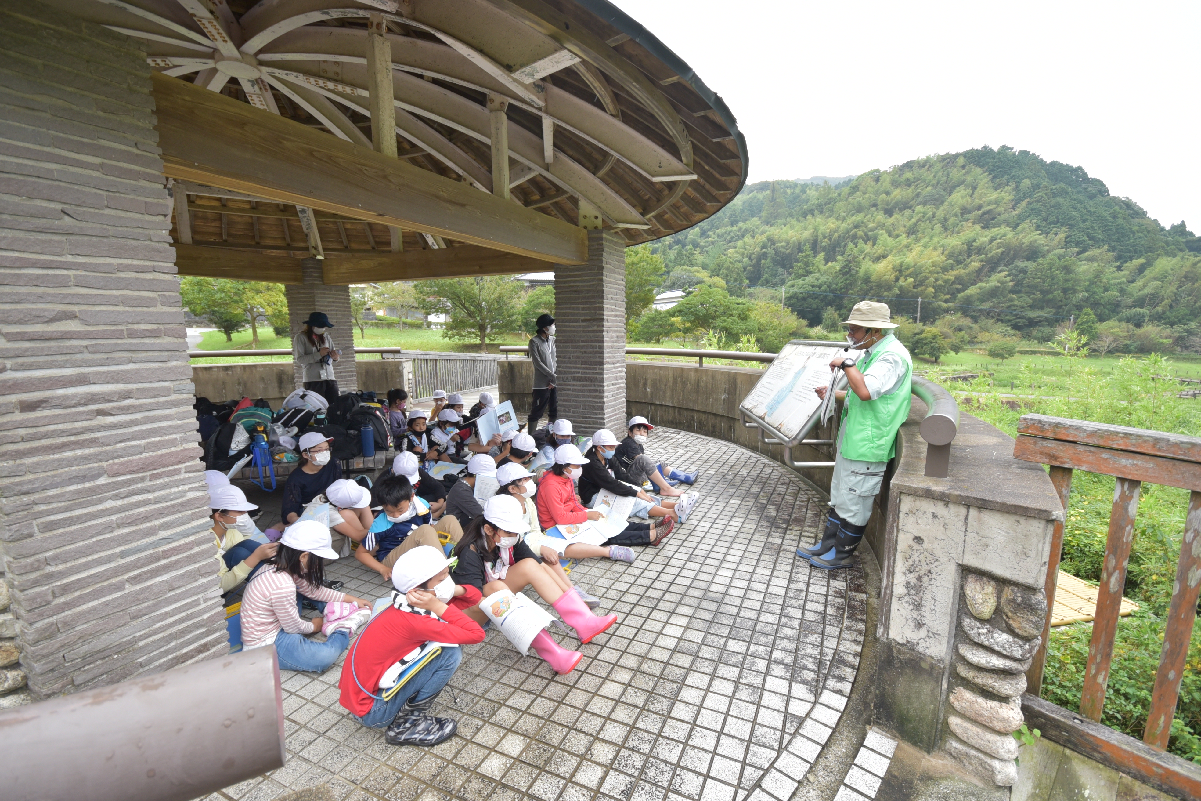 ホタルの里公園で話を聞く子どもたち